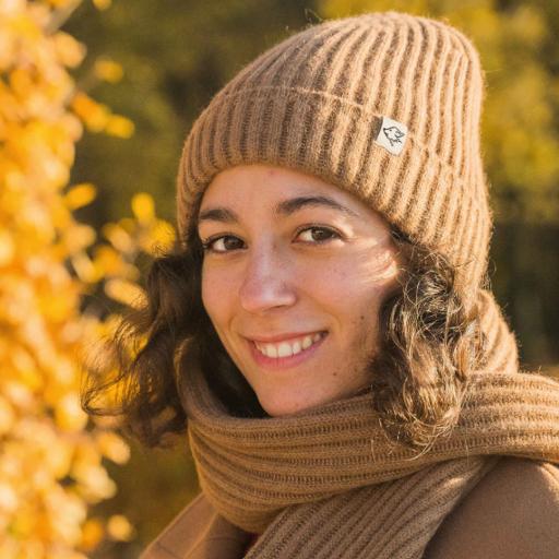 Accessoires aus Kamel- und Yakwolle Frau mit brauner Wollmütze und Schal lacht in Kamera